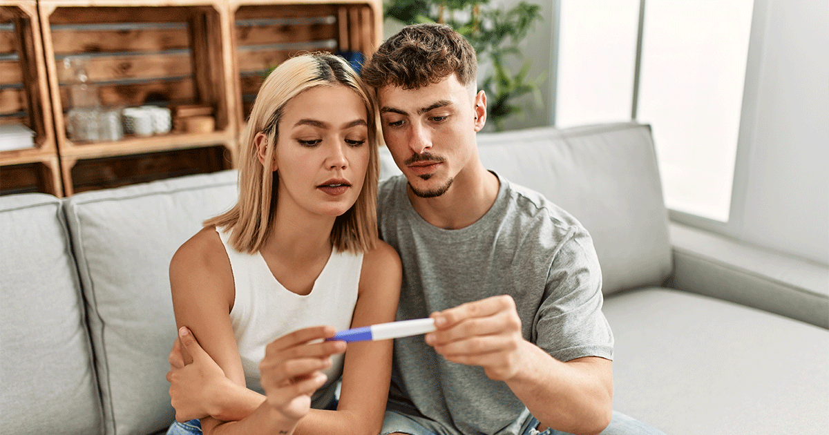 A concerned couple checks a pregnancy test after having unprotected sex.
